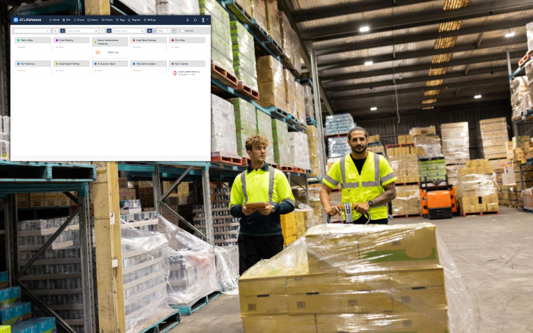 Stacked pallets in the receiving zone of a modern distribution centre, with a discreet location beacon visible on the foreground pallet.
